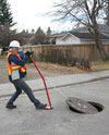 Manhole cover removal tool Utility worker removing manhole cover using Camlift lifter.